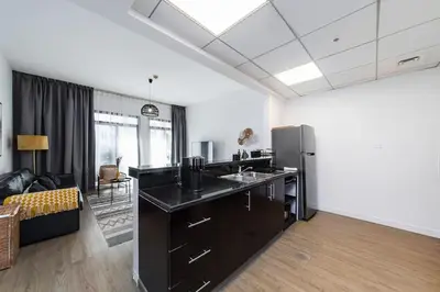 a kitchen with a black counter top and a refrigerator at Bright 1Bdr at Fortunato in Dubai