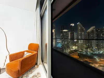 a chair in a room with a view of a city at Luxury Apartments at Paramount Midtown by Dale Lee in Dubai