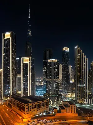 a city skyline at night with a lot of tall buildings at Luxury Apartments at Paramount Midtown by Dale Lee in Dubai
