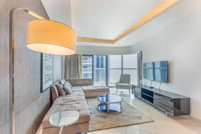 a living room with a couch and a tv at 3 Bed in DAMAC Paramount by PK Holidays in Dubai