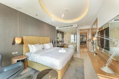 a bedroom with a bed and a chair in a room at 3 Bed in DAMAC Paramount by PK Holidays in Dubai