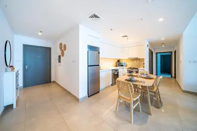 a kitchen and dining room with a table and chairs at Homes Beyond I 2 BR Apartment with Panoramic Creek View in Dubai