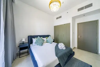 a bedroom with a bed and a chandelier at Homes Beyond I 2 BR Apartment with Panoramic Creek View in Dubai