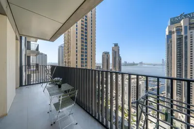 a balcony with a view of the water and buildings at Homes Beyond I 2 BR Apartment with Panoramic Creek View in Dubai
