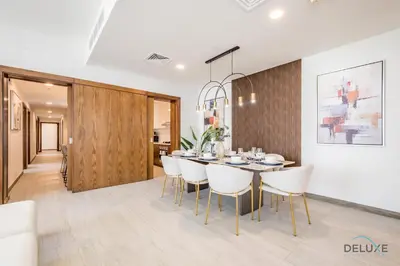 a dining room with a table and white chairs at Spectacular 4BR Penthouse with Assistant Room in Hameni Tower, JVC by Deluxe Holiday Homes in Dubai