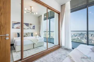 a bedroom with a bed and a large window at Spectacular 4BR Penthouse with Assistant Room in Hameni Tower, JVC by Deluxe Holiday Homes in Dubai