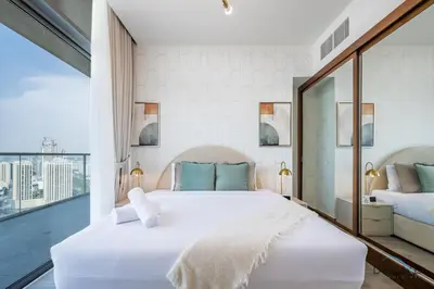 a bedroom with a white bed and a large window at Spectacular 4BR Penthouse with Assistant Room in Hameni Tower, JVC by Deluxe Holiday Homes in Dubai