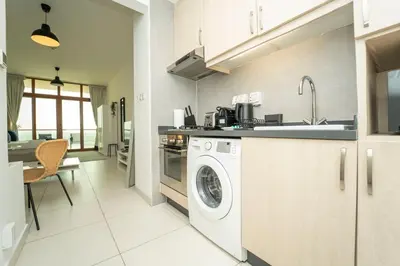a kitchen with a washing machine and a sink at AWS Holiday Homes - Stylish Gem in the Palm in Dubai