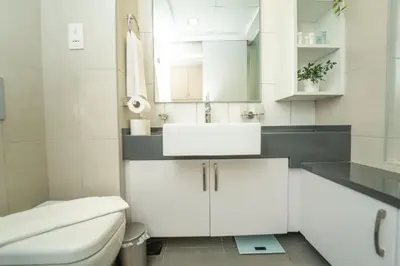 a white bathroom with a sink and a toilet at AWS Holiday Homes - Stylish Gem in the Palm in Dubai