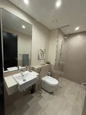 a bathroom with a sink and a toilet and a mirror at Luxury 2BR Close to Sheikh Zayed Rd, Prime Location, Burj View Opposite Metro in Dubai