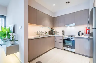 a kitchen with brown cabinets and a stove at Splendid 2BR Apartment at Act One Act Two Tower 2 in Downtown Dubai by Deluxe Holiday Homes in Dubai