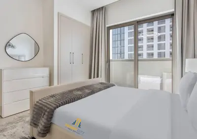 a white bedroom with a large bed and a window at Fully Furnished 2 Bed in Sobha Creek Vista Reserve, Hosted by Desert City Stays in Dubai