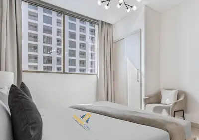 a white room with a bed and a window at Fully Furnished 2 Bed in Sobha Creek Vista Reserve, Hosted by Desert City Stays in Dubai