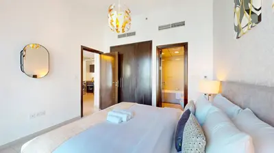 a bedroom with a white couch and a mirror at Bay Central 1 - One Bed with Stunning Marina View in Dubai