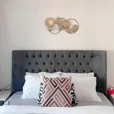 a bed with a gray headboard and two pillows at Fully Furnished Marina View - 1 Bedroom Apartment in Dubai