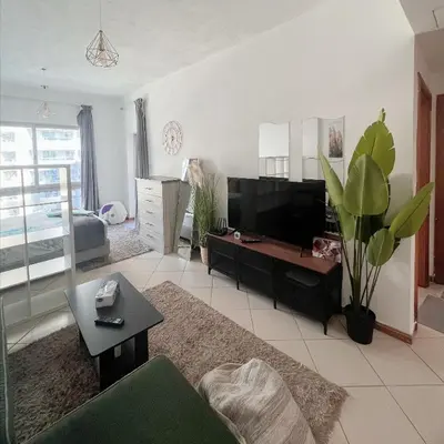 a living room with a couch and a table at Fully Furnished Marina View - 1 Bedroom Apartment in Dubai