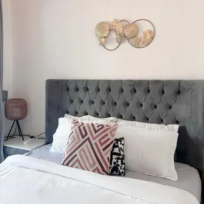 a bed with a gray headboard and pillows on it at Fully Furnished Marina View - 1 Bedroom Apartment in Dubai