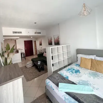 a bedroom with a bed and a living room at Fully Furnished Marina View - 1 Bedroom Apartment in Dubai