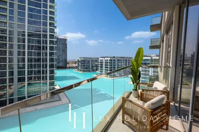 a balcony with a view of a swimming pool at LUX 2BR Lagoon View District One, 10 to 15 min Burj Khalifa in Dubai