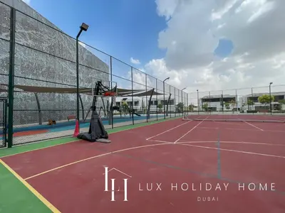 a tennis court with a video camera on it at LUX 2BR Lagoon View District One, 10 to 15 min Burj Khalifa in Dubai