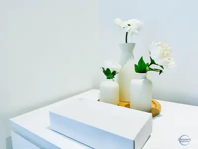 three white vases with flowers on a table at Stylish 2BR Escape 2 Balconies Pool View in Dubai