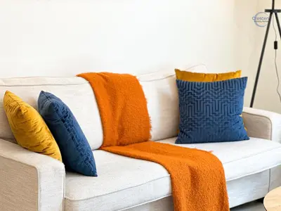 a white couch with orange and blue pillows on it at Stylish 2BR Escape 2 Balconies Pool View in Dubai