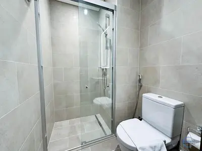 a bathroom with a toilet and a glass shower at Stylish 2BR Escape 2 Balconies Pool View in Dubai