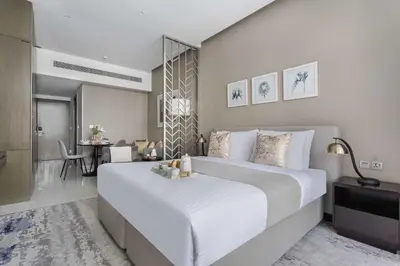 a bedroom with a large white bed and a table at Frank Porter - Damac Prive A in Dubai