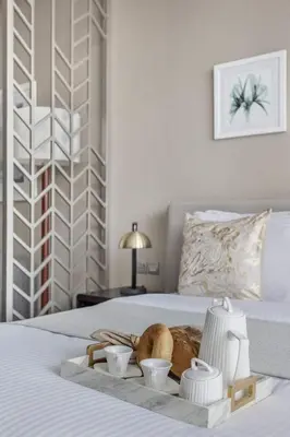 a tray with bread and cups on a bed at Frank Porter - Damac Prive A in Dubai