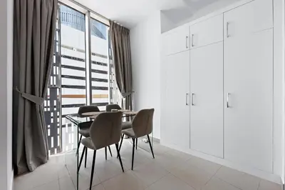 a dining room with a table and chairs and a window at Stayis -Studio in Twisted Tower Dubai Marina in Dubai