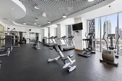 a gym with cardio equipment in a building with skyscrapers at Stayis -Studio in Twisted Tower Dubai Marina in Dubai