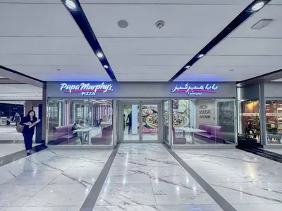 a woman walking through a shopping mall with a store at FIRST CLASS 1BR Luxurious DIFC Retreat in Dubai
