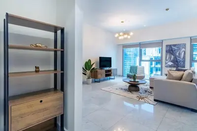 a living room with a couch and a living room with a tv at FIRST CLASS 1BR Luxurious DIFC Retreat in Dubai