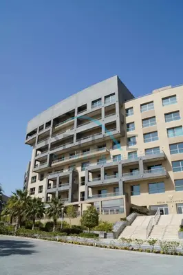 a large apartment building with palm trees in front of it at Waterfront 2BR Apartment with Assistant Room in Dream Palm Residence, Palm Jumeirah by Deluxe Holiday Homes in Dubai