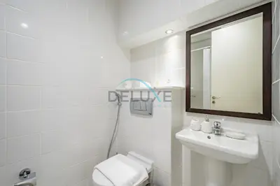 a bathroom with a toilet and a sink and a mirror at Waterfront 2BR Apartment with Assistant Room in Dream Palm Residence, Palm Jumeirah by Deluxe Holiday Homes in Dubai