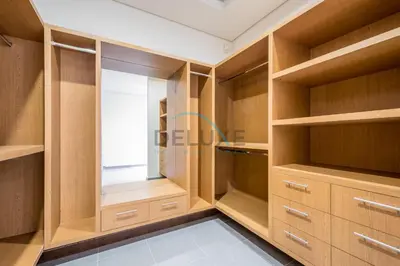 a walk in closet with wooden cabinets and a window at Waterfront 2BR Apartment with Assistant Room in Dream Palm Residence, Palm Jumeirah by Deluxe Holiday Homes in Dubai