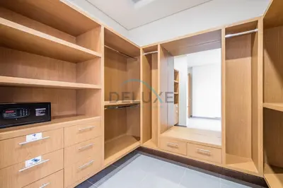 a walk in closet with wooden cabinets and a window at Waterfront 2BR Apartment with Assistant Room in Dream Palm Residence, Palm Jumeirah by Deluxe Holiday Homes in Dubai