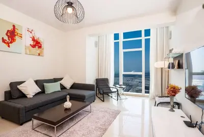 a living room with a couch and a table at Duplex Suite in 5-Star Movenpick Hotel in Dubai