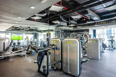 a gym with several treadmills and machines at Duplex Suite in 5-Star Movenpick Hotel in Dubai