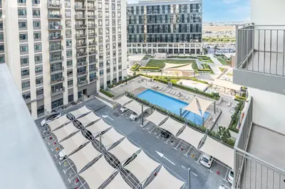 an aerial view of a building with a pool and buildings at Nicely Furnished 2BR Home in Dubai Hills in Dubai