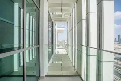 an empty corridor in a building with glass windows at RH - Stunning Canal View 01 BR with Top amenities, newly furnished in Dubai