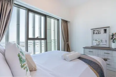 a bedroom with a white bed with a large window at RH - Stunning Canal View 01 BR with Top amenities, newly furnished in Dubai