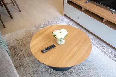 a table with a remote control and a vase of flowers at RH - Stunning Canal View 01 BR with Top amenities, newly furnished in Dubai