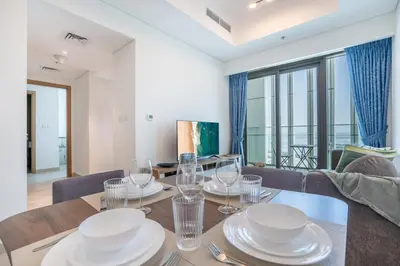 a dining room with a table with plates and glasses at RH - Stunning Canal View 01 BR with Top amenities, newly furnished in Dubai