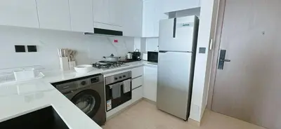 a white kitchen with a refrigerator and a stove at Bright & Cozy 1br Jvc Balcony Free Parking in Dubai