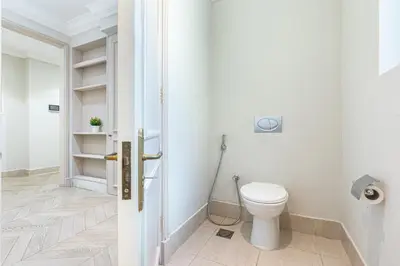 a white bathroom with a toilet and a door at Souk Al Bahar Home with direct Dubai Mall Access in Dubai