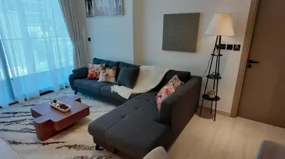 a living room with a couch and a table at Chic Comfort - Stylish One-Bedroom in Dubai