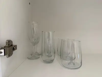 four empty wine glasses sitting on a counter at Chic Comfort - Stylish One-Bedroom in Dubai