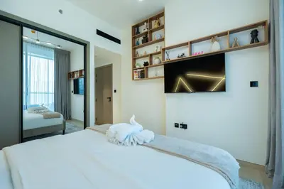 a bedroom with a white bed and a mirror at Chic Comfort - Stylish One-Bedroom in Dubai