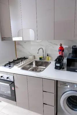 a kitchen with a sink and a stove at Nasma Luxury Stays - Trendy & Stylish Living Studio at Azizi Riviera 41 in Dubai